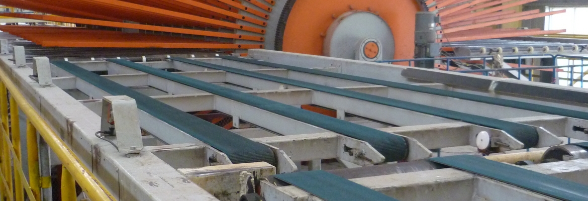 Nach dem Pressen werden die Platten zu einem riesigen Kühlrad, auch Sternwender genannt, transportiert, wo sie (durch die Luft) gekühlt und gewendet werden.